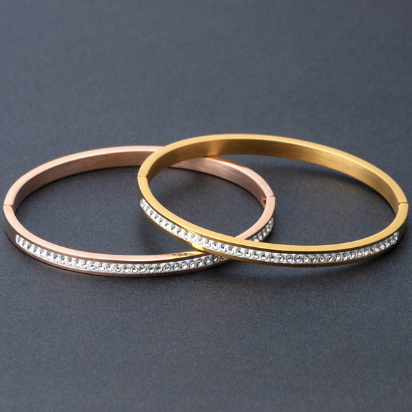 elegant white stone bracelet set with gold and rose gold tones on a dark background