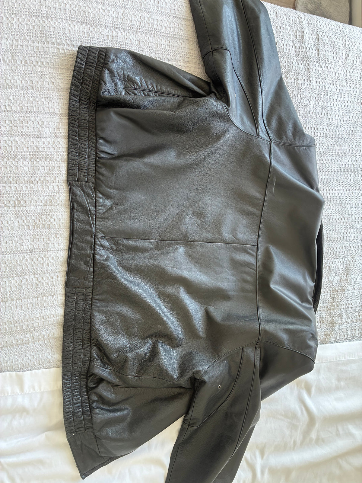 Original back view of the Danier leather jacket, showing seams, creasing, and elasticated waist.