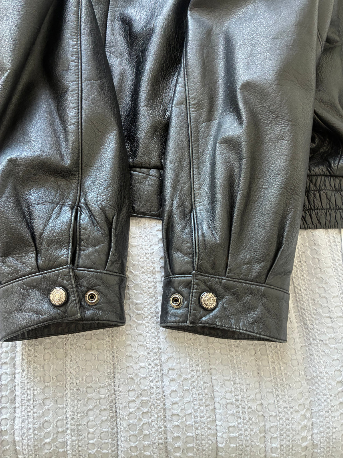 Original photograph of Danier jacket cuffs showing snap fasteners and surface wear