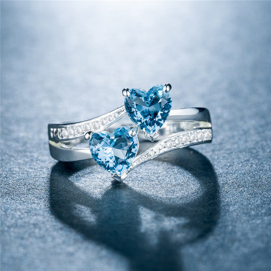affordable luxury rings for women featuring silver bands with heart-shaped blue gemstones and small clear crystals