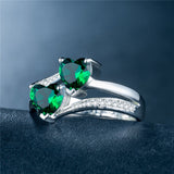 affordable luxury rings for women with two heart-shaped green gemstones and diamond accents