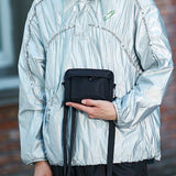 affordable men's phone case bag in black worn with light silver jacket by model