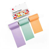 Printer paper rolls in purple, green, and orange for use with a bluetooth mini thermal label printer