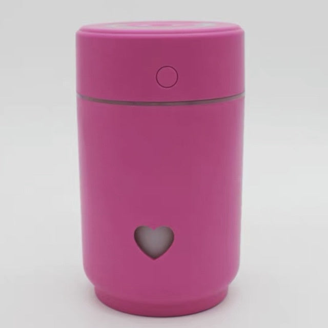 Pink compact car air purifier with a heart-shaped cutout for stylish air cleaning on the go