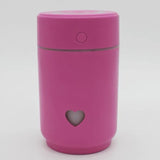 Pink compact car air purifier with a heart-shaped cutout for stylish air cleaning on the go