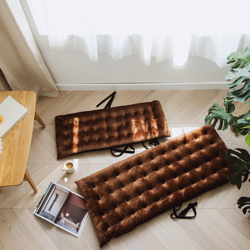 cozy chair for reading and relaxation brown tufted cushions placed on light wood floor near table and plants