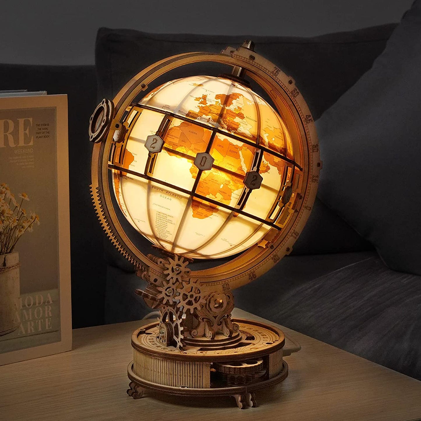 3D wooden globe model kit illuminated on a table showing detailed wooden gears and map