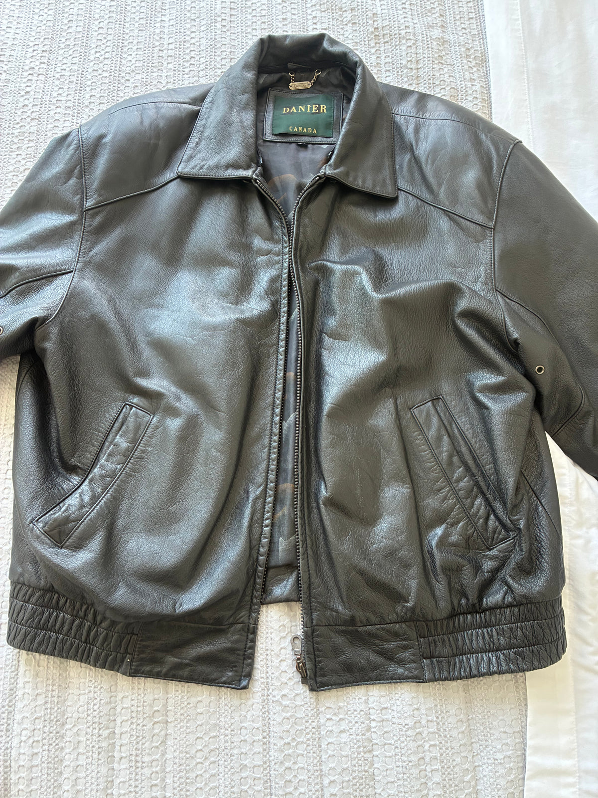 Original front view of the pre-owned Danier leather jacket, showing zip front, pockets, and leather creasing.