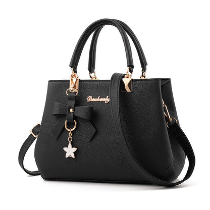 Elegant black laptop messenger bag for women with bow detail and detachable charm