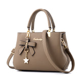Stylish taupe laptop messenger bag for women with bow detail and detachable charm