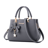 Stylish gray laptop messenger bag for women with a bow and charm details for everyday use