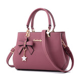 Stylish pink laptop messenger bag for women with bow detail and detachable charm