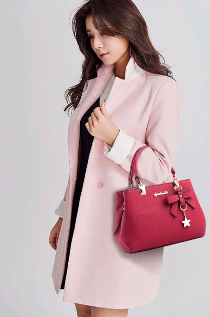 Stylish red handbag with bow detail, perfect as a laptop messenger bag for women
