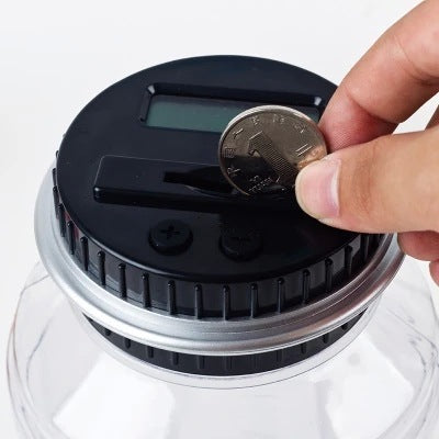Close-up of electronic coin counter jar with a hand inserting a coin into the slot