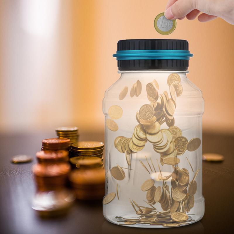 Clear electronic coin counter jar with a hand inserting a coin and scattered coins around