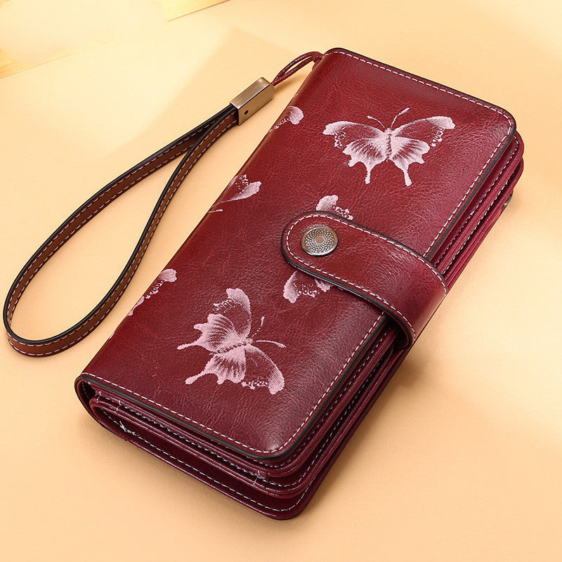 Elegant leather wallet for women in red with butterfly design and wrist strap by StoreFour