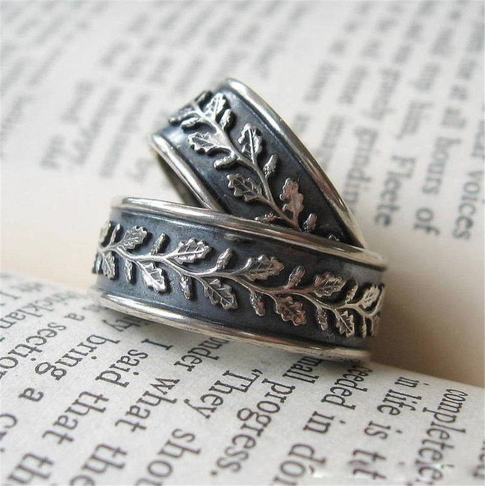 European style unisex leaf ring in silver with intricate leaf designs on a dark band