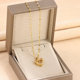 gold heart necklace with double layer love pendant for women displayed in beige jewelry box