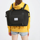 black compact work backpack for women with front zip pocket top handles and adjustable shoulder straps