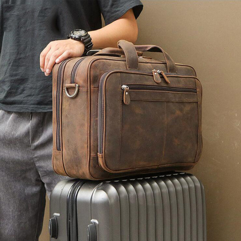 A stylish 17" men's crazy-horse genuine leather business bag resting on a suitcase for travel convenience.