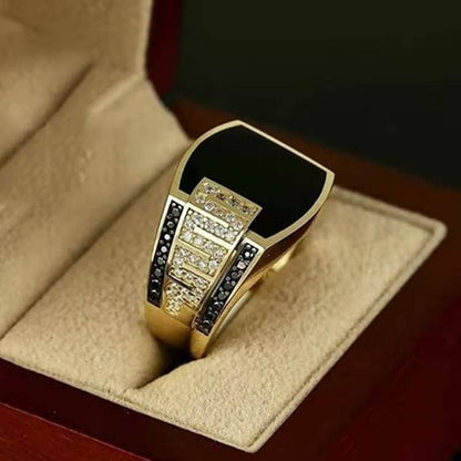 Men's elegant black gemstone ring with gold accents and sparkling details in a display box