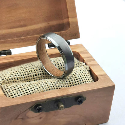 Men's silver tungsten carbide ring displayed in a wooden box with a textured interior