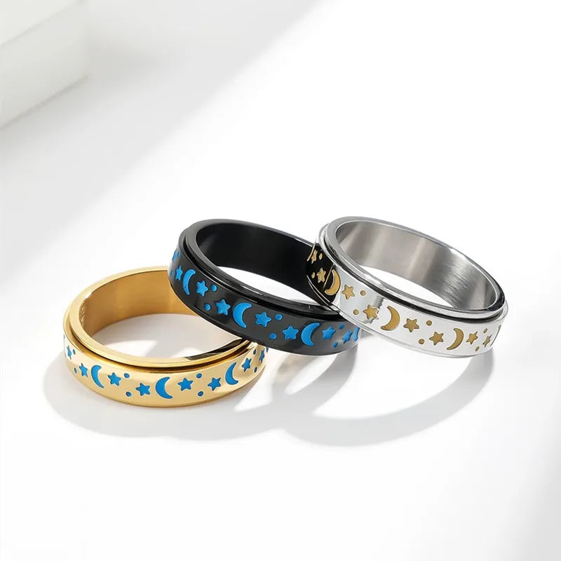 Set of stainless steel star spinner ring in black, gold, and silver with moon and star designs