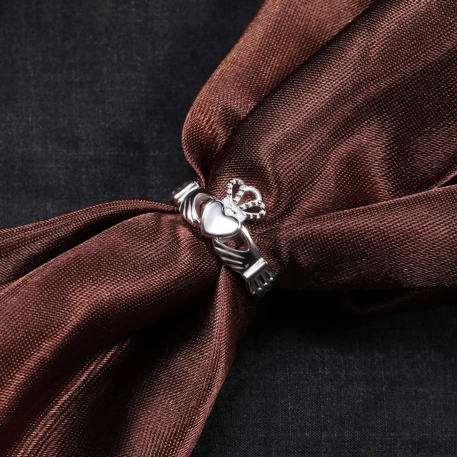 925 sterling silver Irish promise ring for women featuring a heart design on a brown fabric background