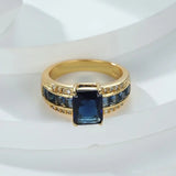 women's retro blue fashion ring featuring a large blue stone and gold band with accent stones