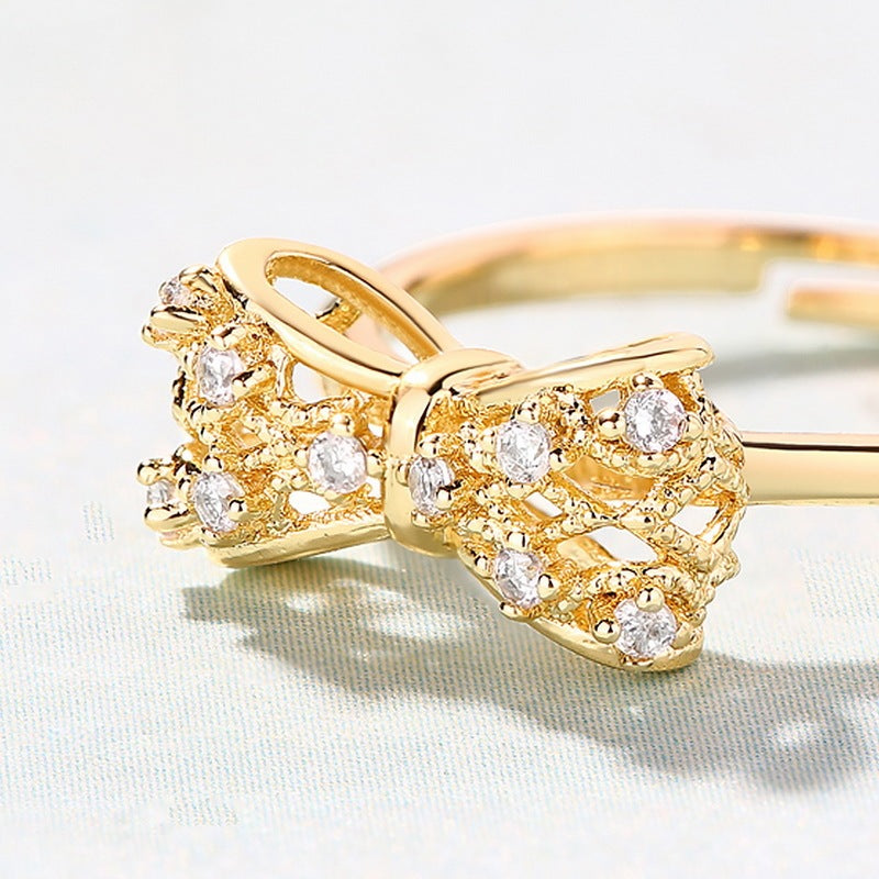 Elegant yellow copper gold-plated women's ring featuring a bow design with sparkling stones