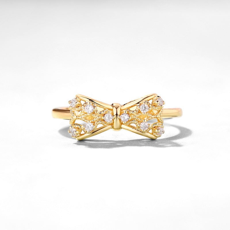Yellow copper gold-plated women's ring featuring a bow design with sparkling accents